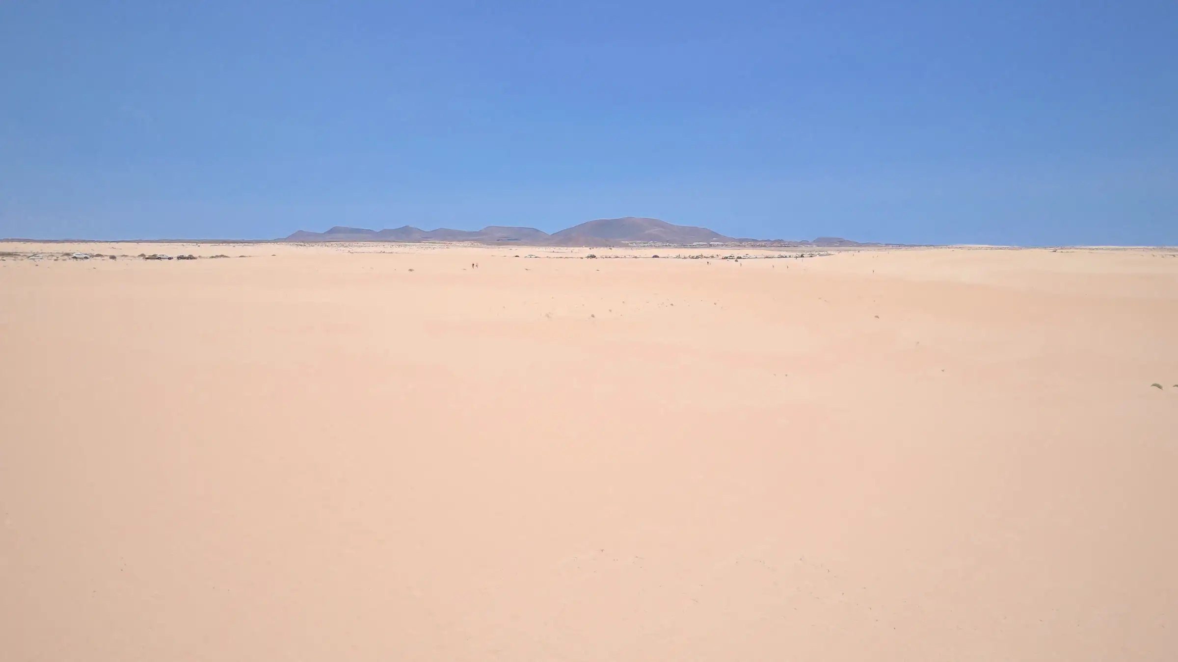 Creste di dune bianche quasi monocrome, con la luce radente che ne segna le ombre