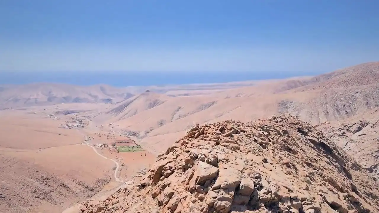 Valli e montagne desertiche di Fuerteventura viste dall'alto, con la luce radente che disegna i crinali
