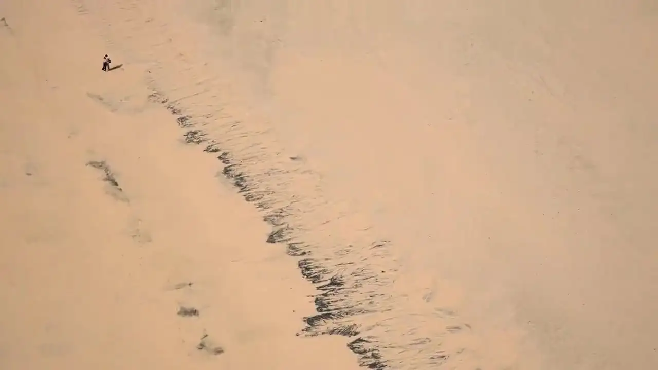 Creste di dune bianche riprese da drone, con la luce radente che ne disegna le ombre