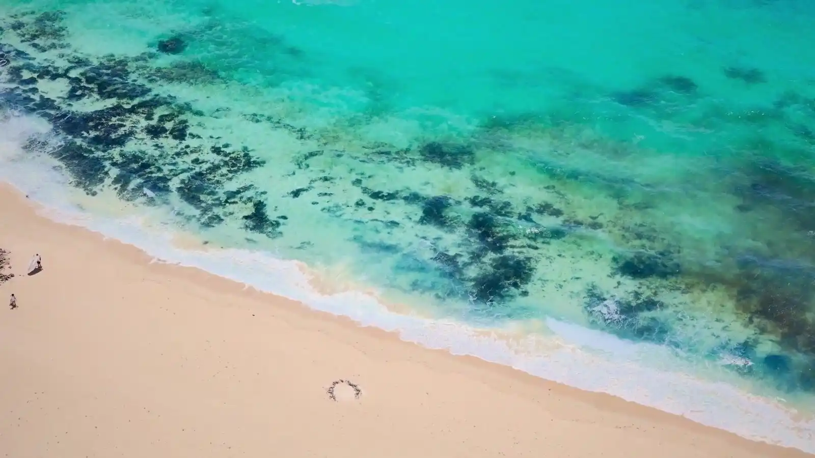 Fotogramma di apertura dello showreel: costa rocciosa e oceano turchese ripresi da drone
